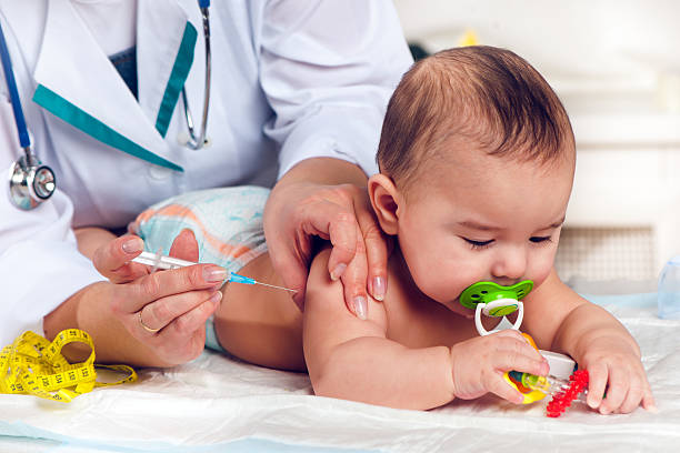 Doctor giving a baby boy injection in arm